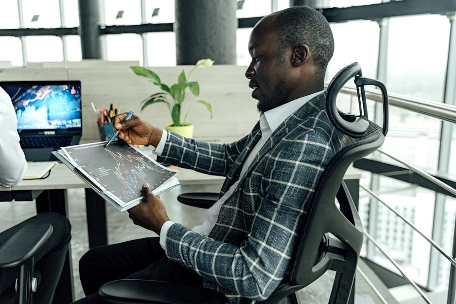 A financial analyst reviewing data on a laptop in a modern office.